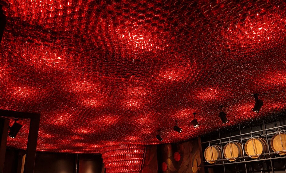 A room with a red textured ceiling and wooden barrels. 3