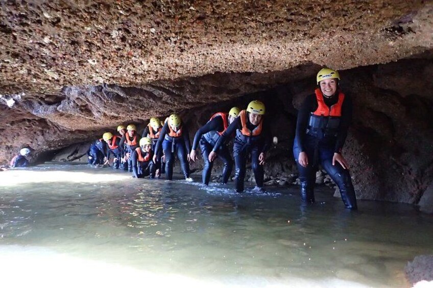 A group of people in helmets and life vests in a cave. 3