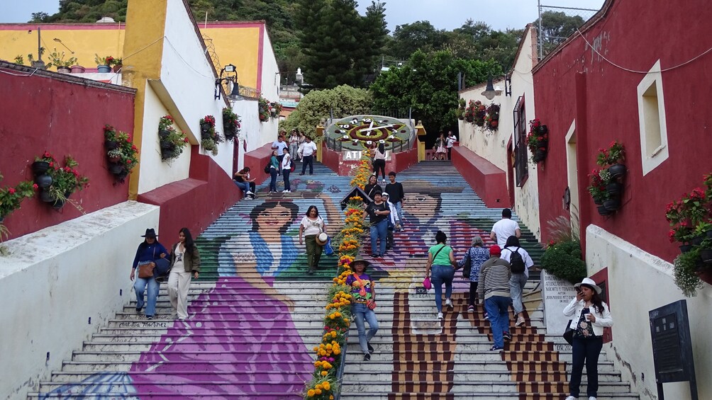 Una escalera con escalones de colores y un reloj grande en la parte superior. 2