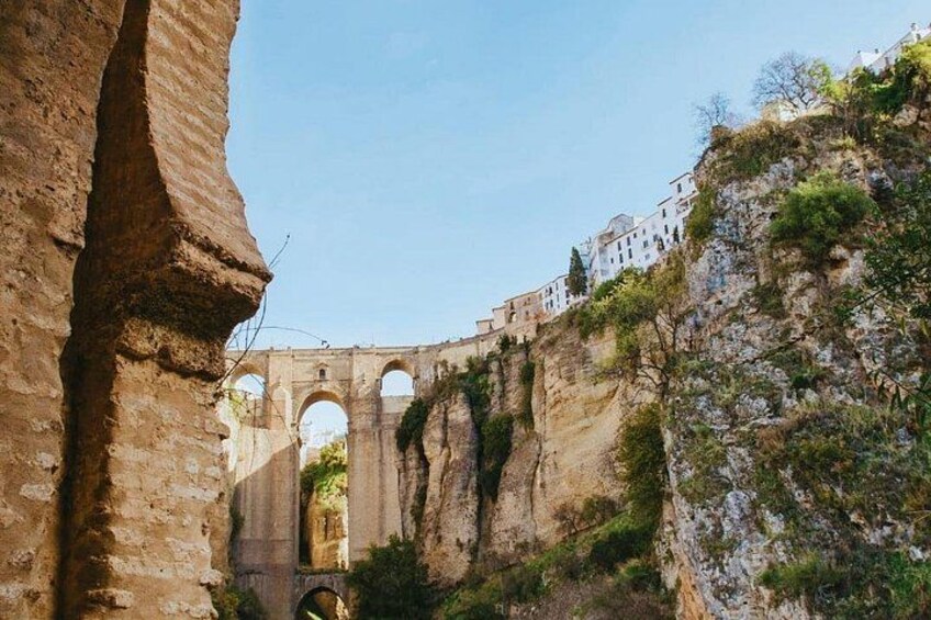 Ancient stone arches, a cliff, and a building on top. 1