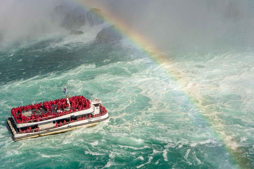 A cruise ship with passengers in red attire amidst turbulent waters and a visible rainbow. 5