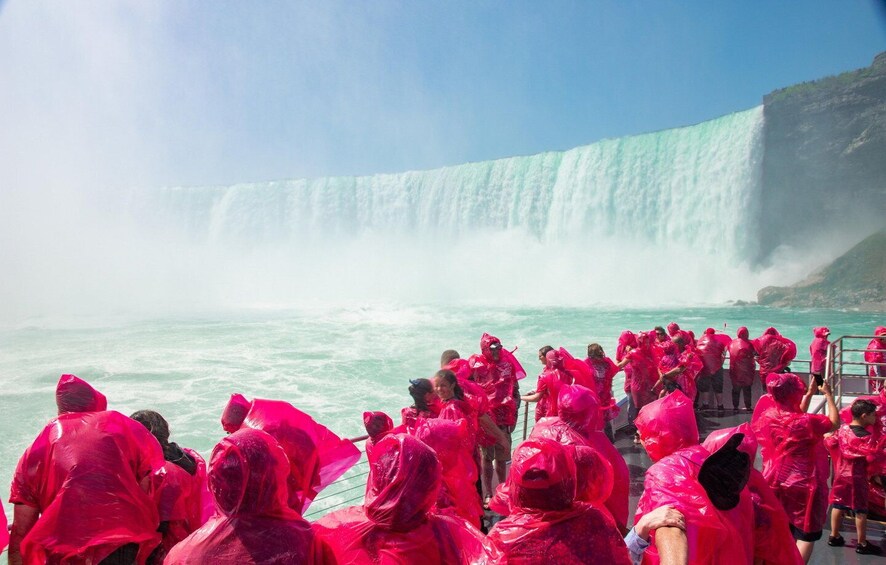 A group of people in bright pink rain ponchos at Niagara Falls. 3