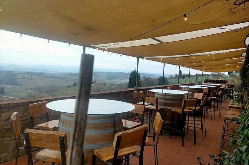 An outdoor dining area with round tables and chairs, overlooking a scenic landscape. 4
