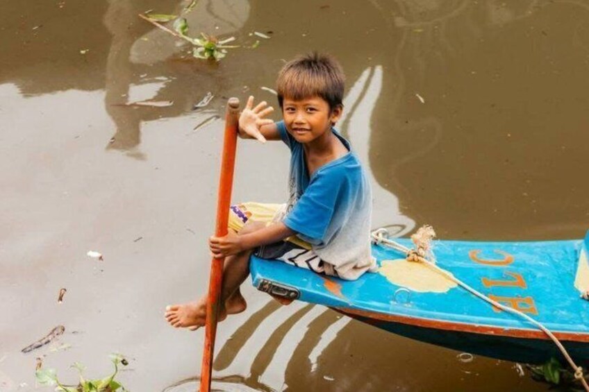 A child sitting on a small boat in a body of water. 3