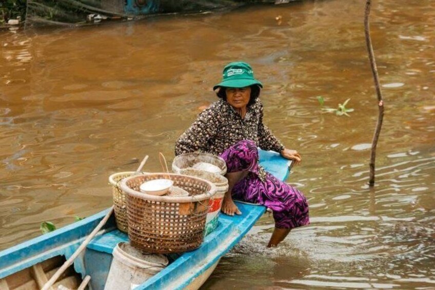 A person in a boat with a basket and a blue container. 5