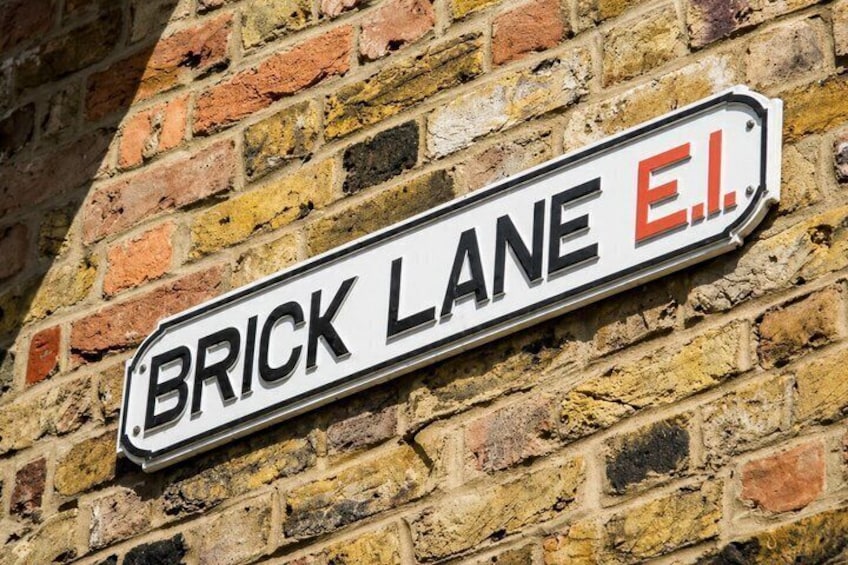 A street sign for Brick Lane E.I. on a brick wall. 1