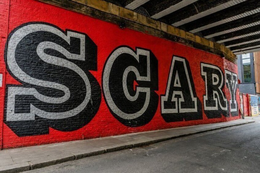 A red wall with the word 'SCARY' painted in large white and black letters. 4