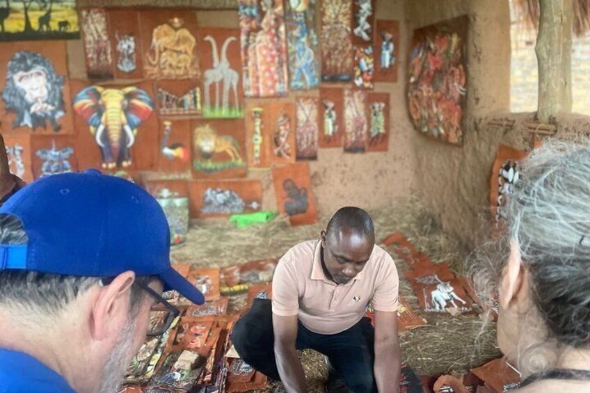 A man sitting on the floor in a room with colorful paintings on the walls. 5