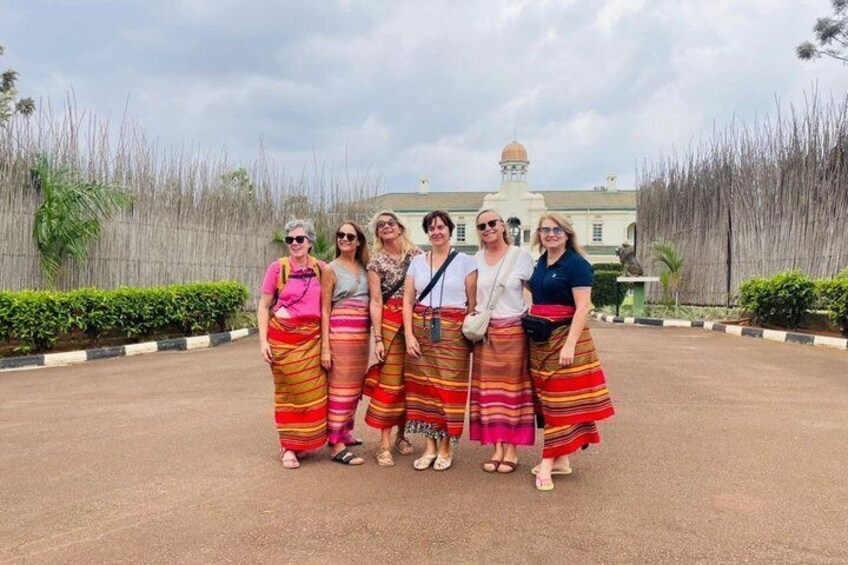 A group of people standing in a formal setting with a building in the background. 1