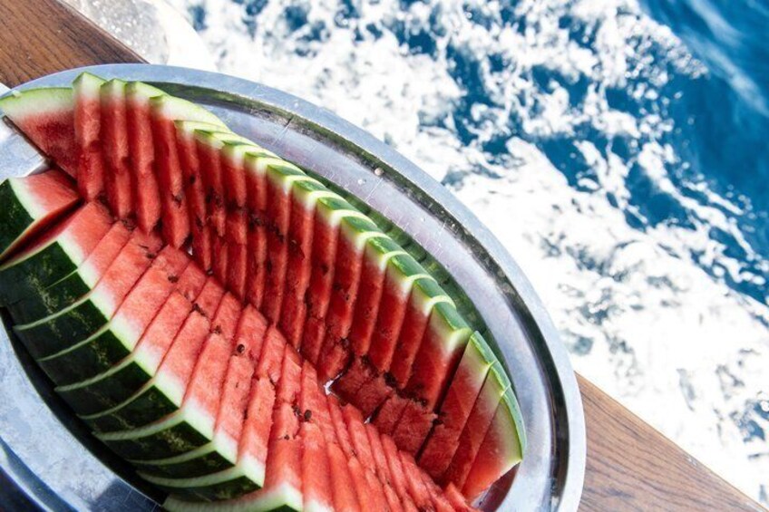 A metal plate with neatly sliced watermelon arranged in a fan shape. 2