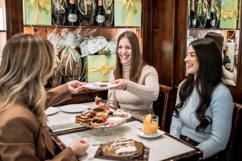 A group of people dining at a restaurant with a table set with various dishes and a bottle of champagne. 1