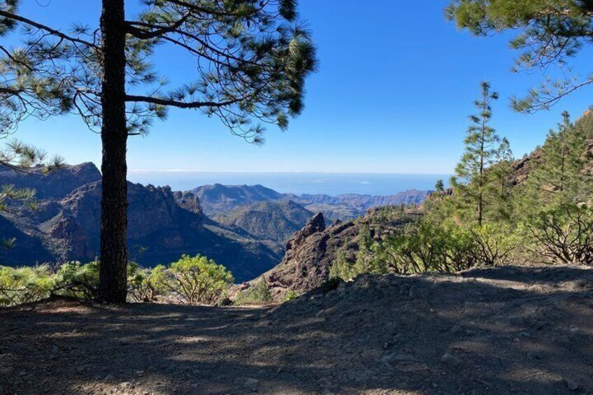 A mountainous landscape with a clear sky, rocky terrain, and sparse vegetation. 5