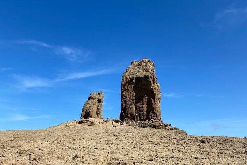 Two rock formations in a desert landscape under a clear blue sky. 1