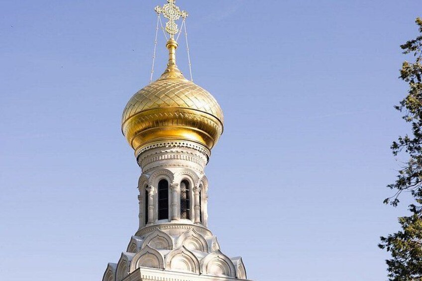 A church with a golden dome and white walls. 2