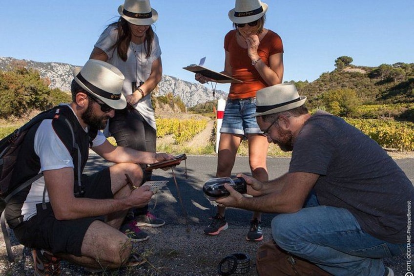 Four people wearing hats, one person taking a photo, and another holding a map. 4