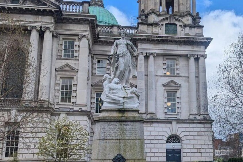 A classical statue in front of a large building with columns and a dome. 3