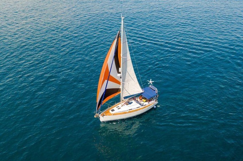 A sailboat with a colorful sail on a calm sea. 4