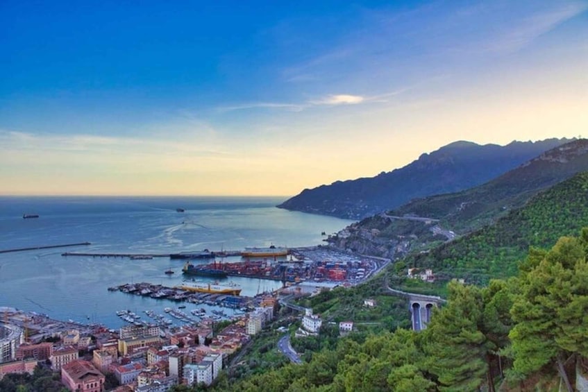 A coastal town with a marina, a mountain range, and a bridge. 5