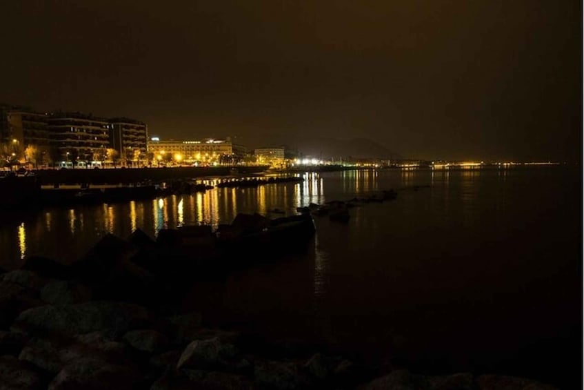 A nighttime waterfront with illuminated buildings reflecting on the water. 4
