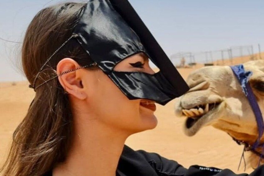A person in a desert environment with a camel. 3