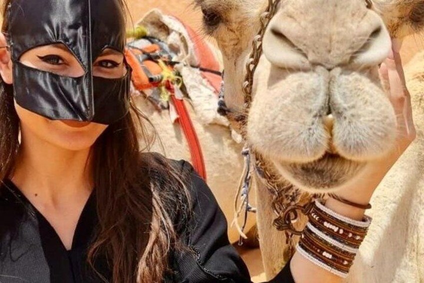 A camel with a person in the background. 2