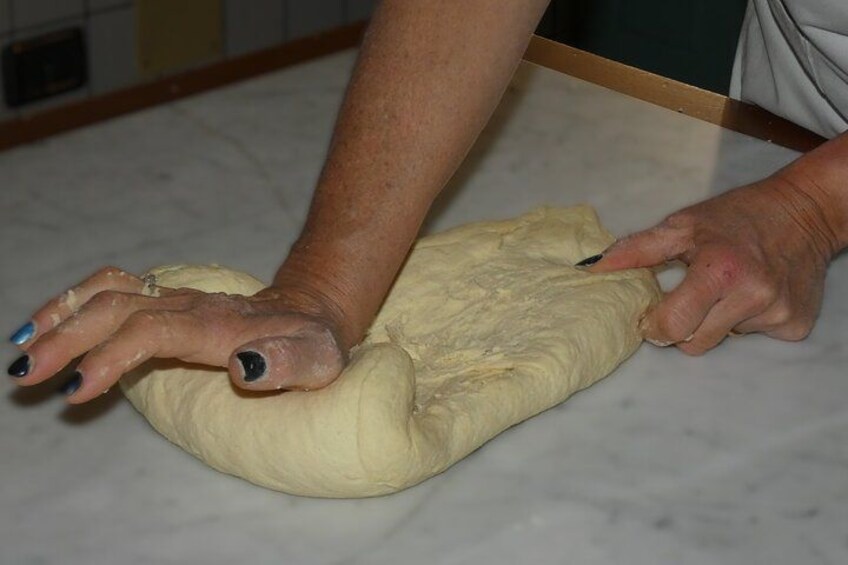 Hands kneading dough on a marble countertop. 5