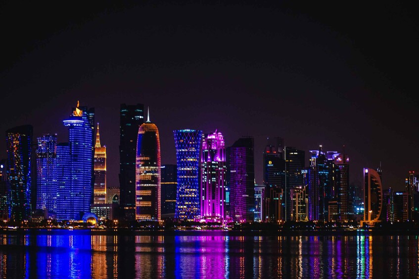A nighttime city skyline with illuminated buildings reflecting on the water. 5