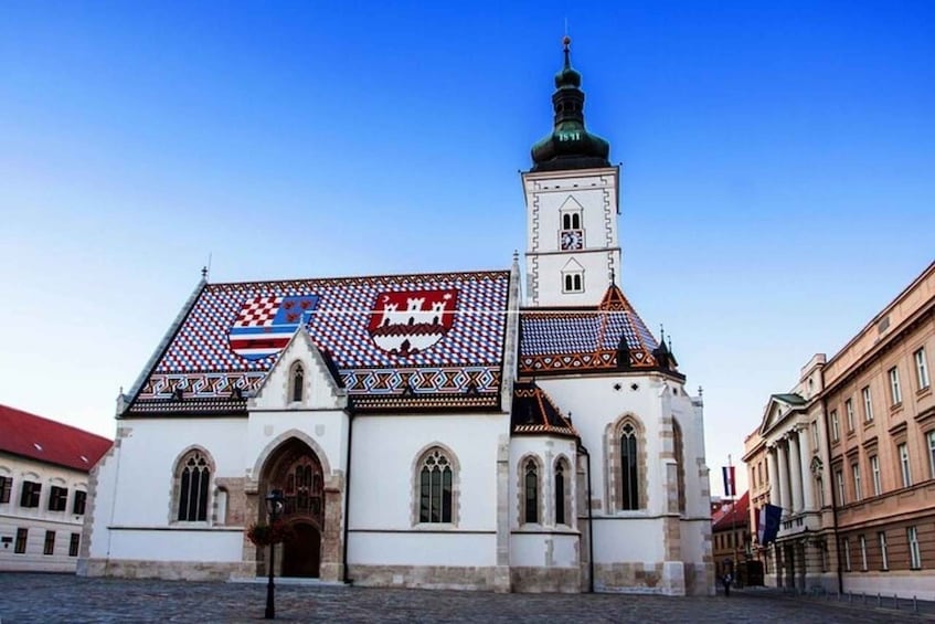 A church with a tiled roof and a clock tower. 3