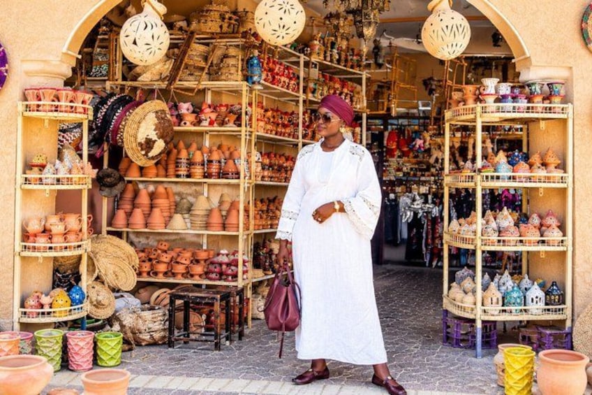 Un étal de marché où sont vendus des articles de poterie et des textiles. 1