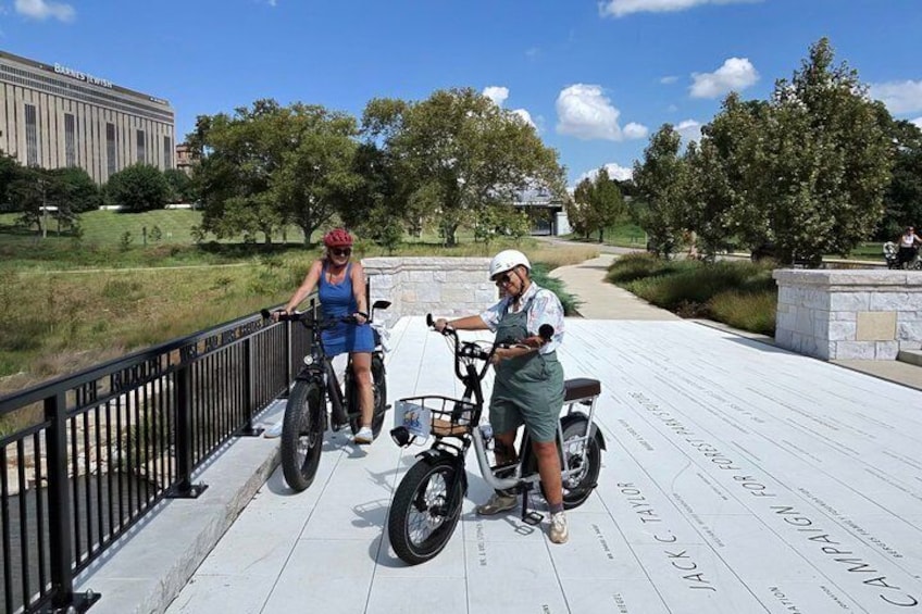 Two people on a bridge with a city building in the background. 4