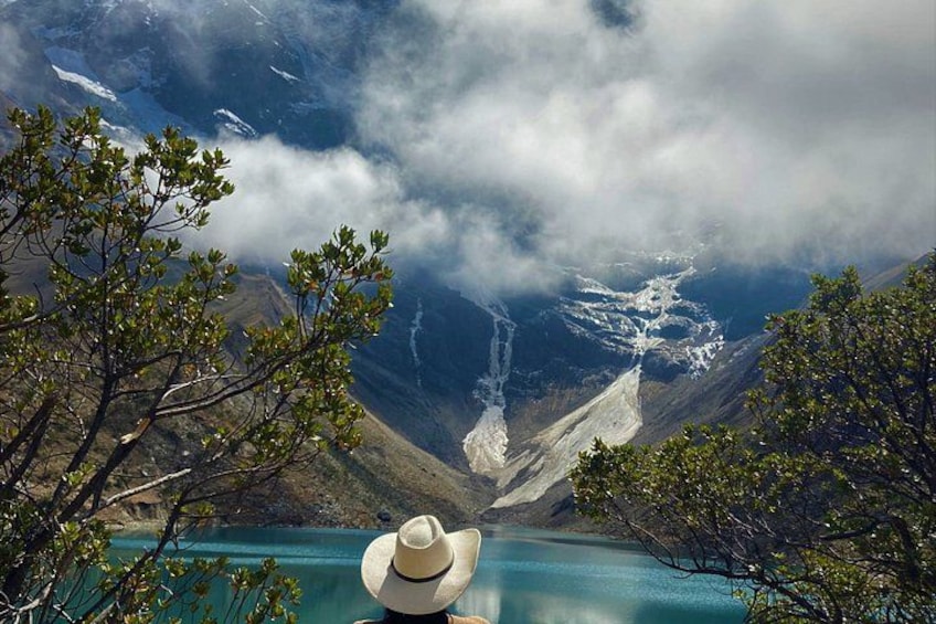 A mountainous landscape with a lake, a waterfall, and a hat in the foreground. 2