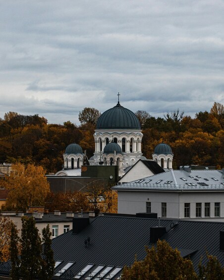 A church with a large central dome and smaller domes, surrounded by autumn trees. 4