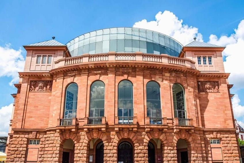 A large, historic building with a central dome and arched windows. 1