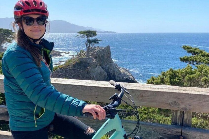 Una persona en bicicleta frente a una vista costera panorámica. 1