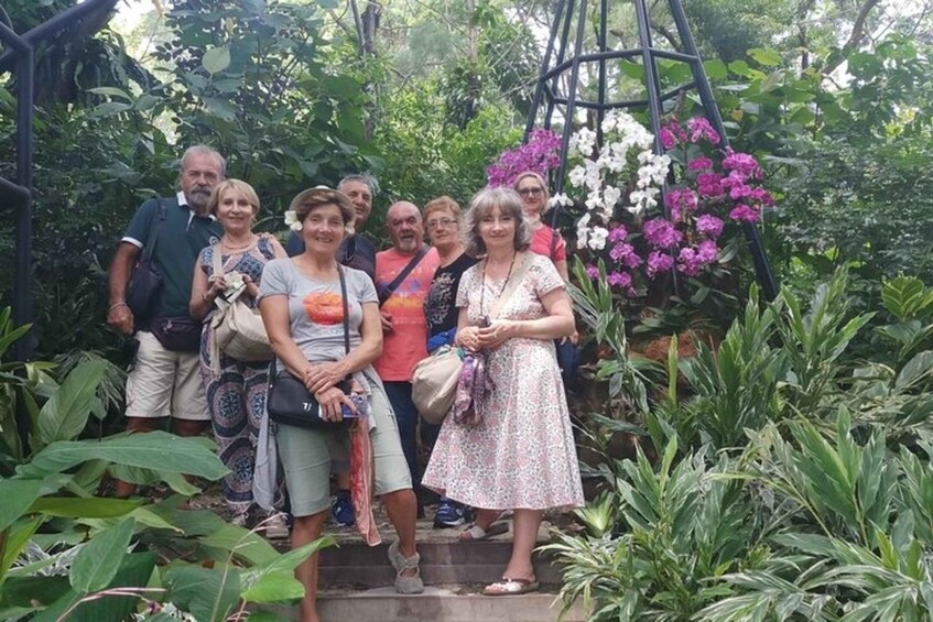 A group of people standing on a staircase surrounded by lush greenery and flowering plants. 1