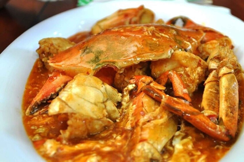 A plate of cooked crabs in a red sauce. 3