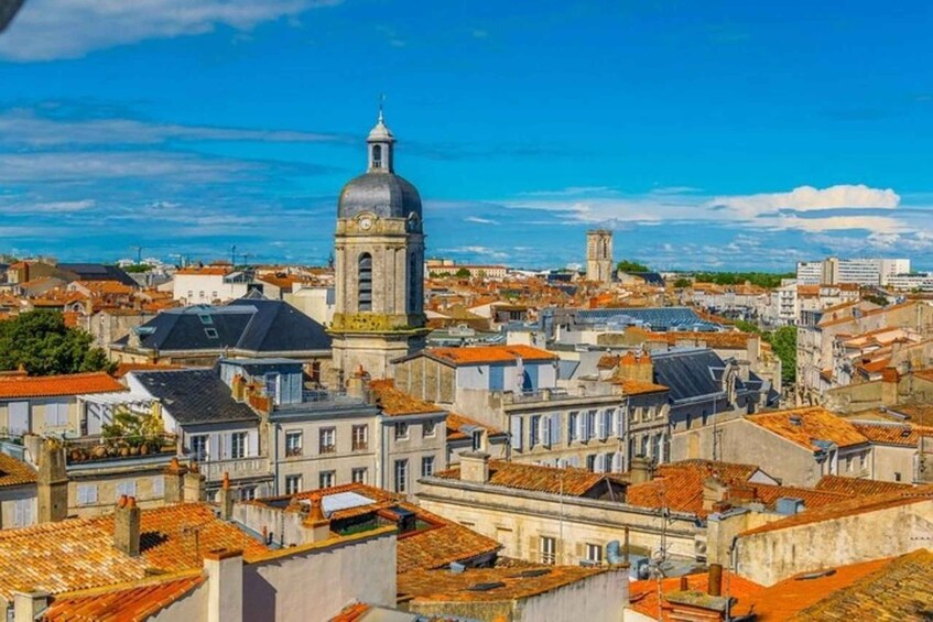 A cityscape with historic buildings, a prominent church with a dome, and a clear blue sky. 3