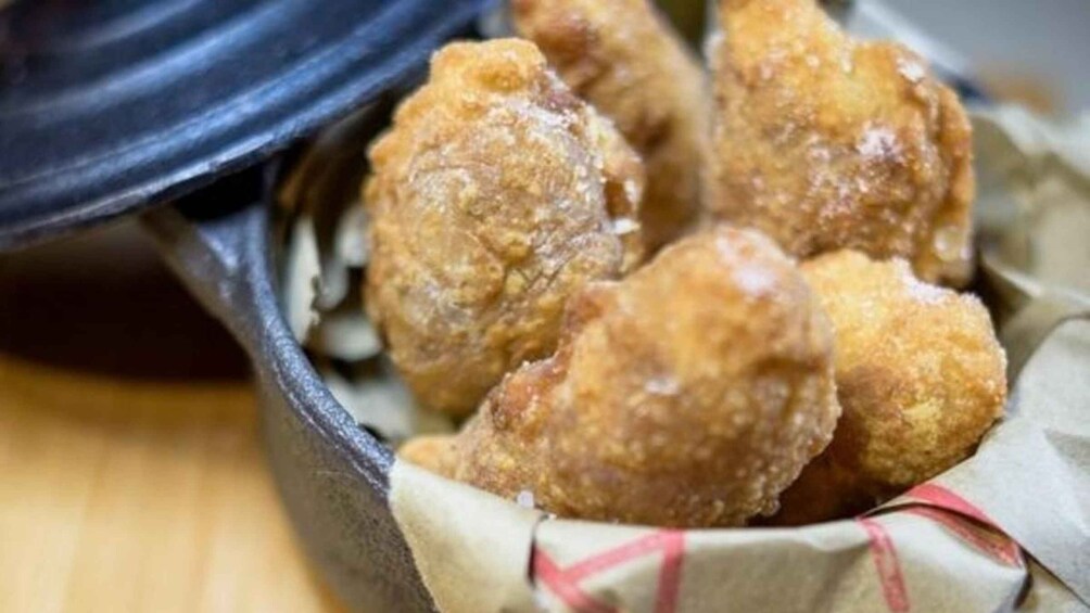 A cast iron skillet filled with golden-brown fried food items. 4