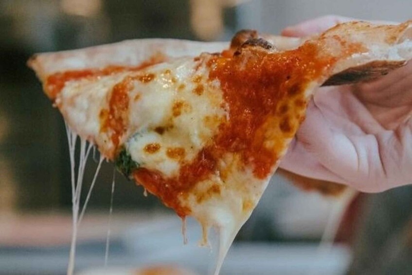 A close-up of a slice of pizza with melted cheese and tomato sauce. 2