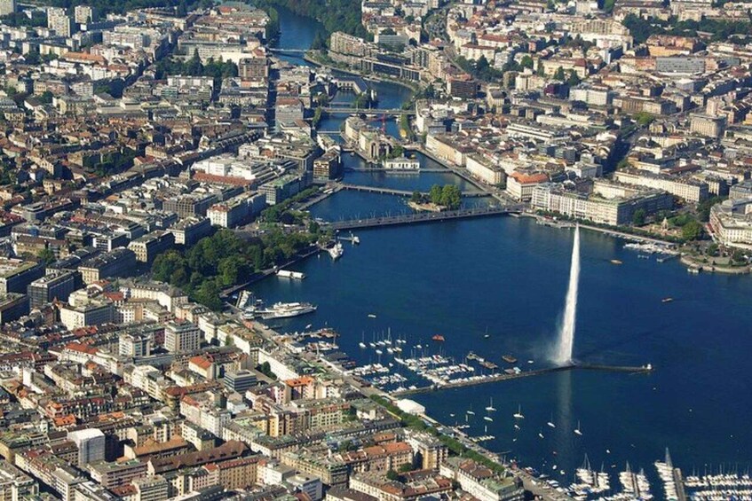 An aerial view of a city with a prominent river, a bridge, and a fountain. 3