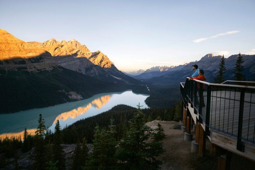A mountain landscape with a lake, forest, and a wooden viewing platform. 1