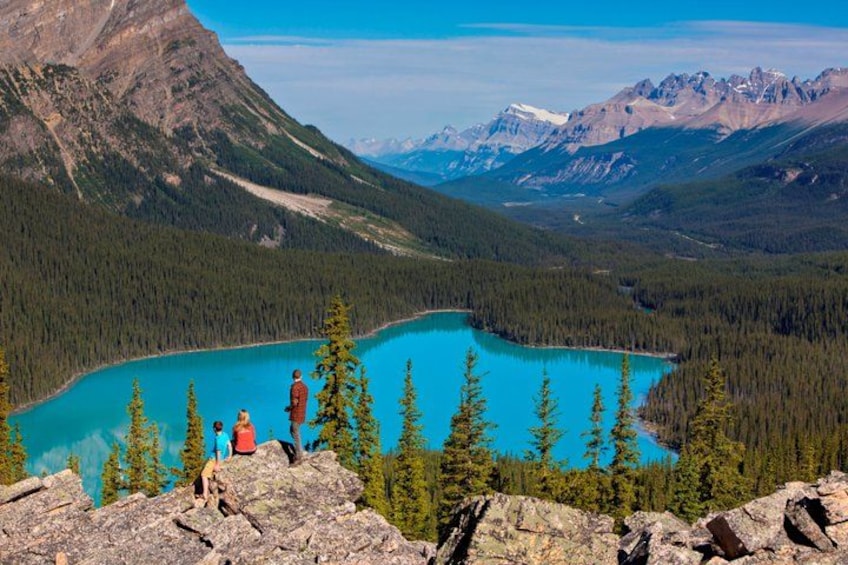 A turquoise lake surrounded by dense forest and mountains. 5