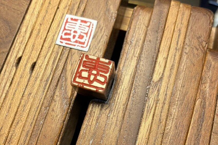 Two wooden blocks with red Chinese characters on a wooden surface. 3