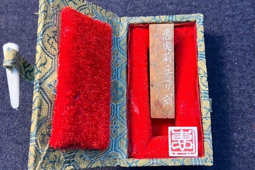 A traditional Chinese medicine box with a red interior, a wooden stick, and a white object. 5