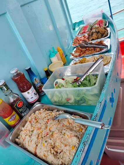 A food stall with various dishes, condiments, and a container of salad. 4