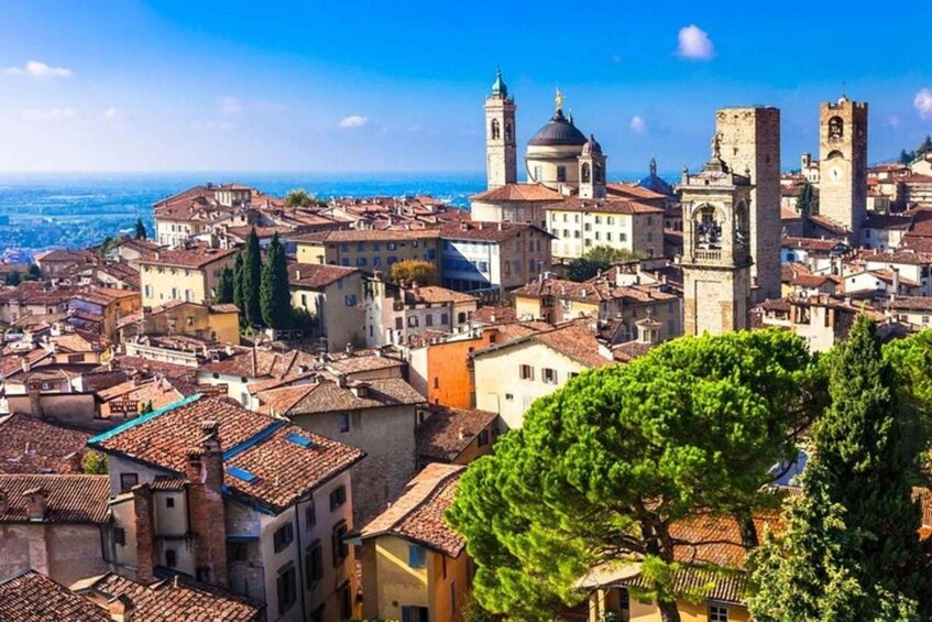 A coastal cityscape with historic buildings, a prominent church with a dome, and a clear view of the sea. 5