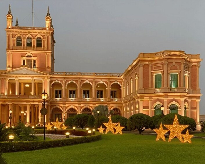 A grand building with a tower, arched windows, and star-shaped lights in the foreground. 5