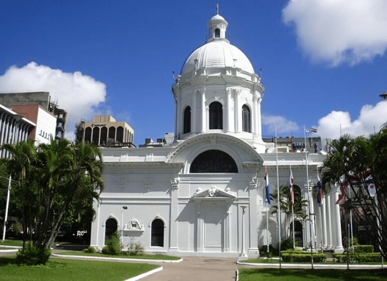 A white colonial-style building with a dome and arched windows. 1