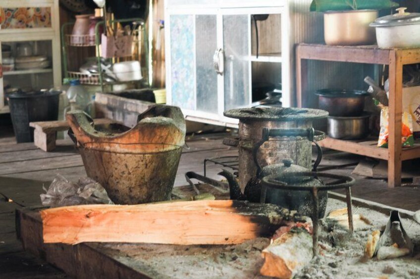 A cluttered kitchen with old cookware, a wooden table, and a window in the background. 4