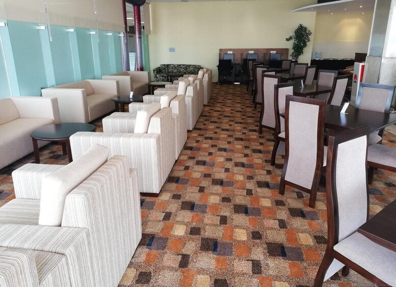A modern lounge area with sofas, chairs, and a patterned carpet. 3
